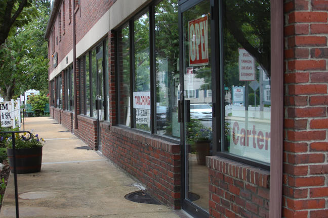 Brick storefront walkway with tall glass windows